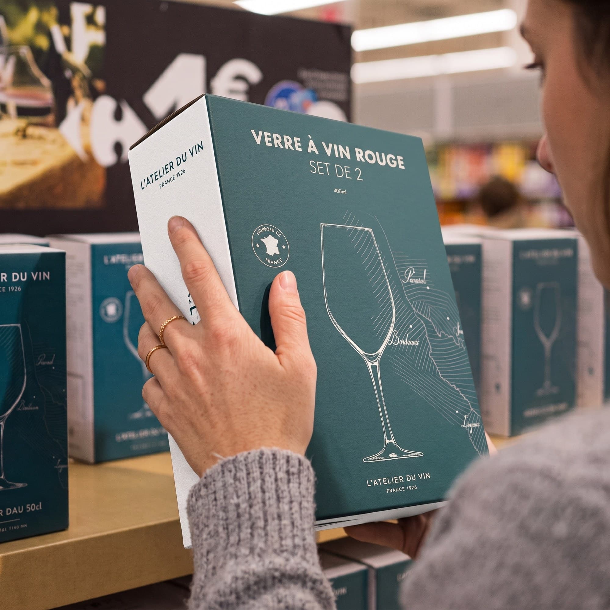 Un pack verre à vin rouge en main, dans le rayon